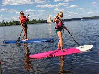 A mother and daughter enjoy the stand up paddle boards