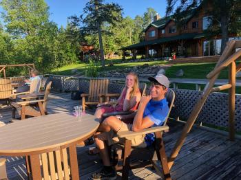 Couple enjoys a glass of wine on the Sun Deck at Pehrson Lodge
