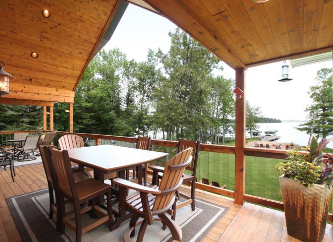 Deck area overlooking the yard and beach area, with plenty of seating.