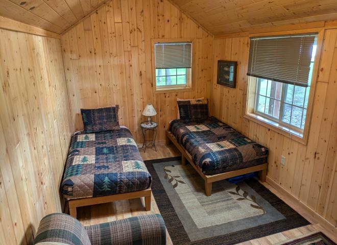 Bunk house with two twin beds, couch, and no plumbing.