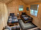 Summer bunkhouse with two twin beds and a couch.