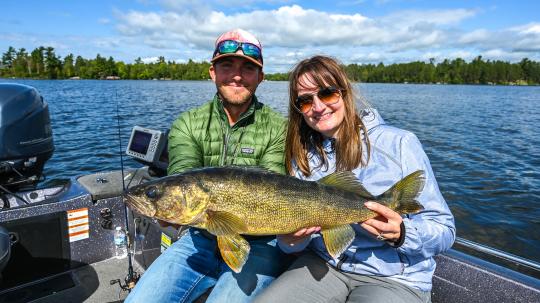 Fishing guide and client holding walleye