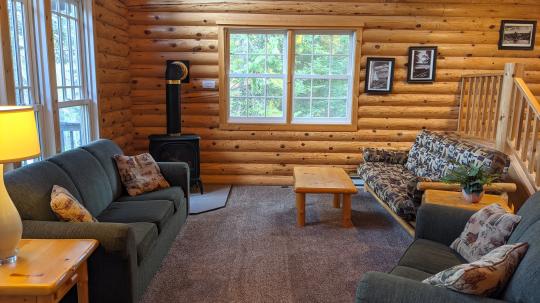 Living room with couch, love seat, futon, and gas fireplace.