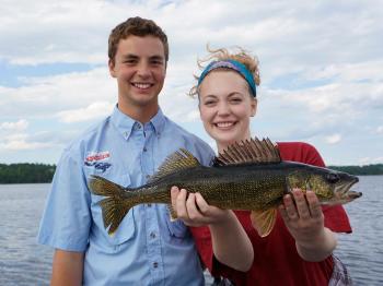 Brother and sister fisherpeople show off a perfect walleye