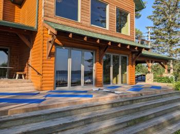 Front of the lodge with yoga mats set up facing the lake.