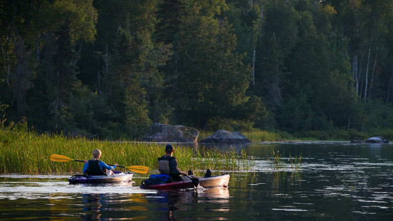 Man and woman kayaking on Lake Vermilion at sunset