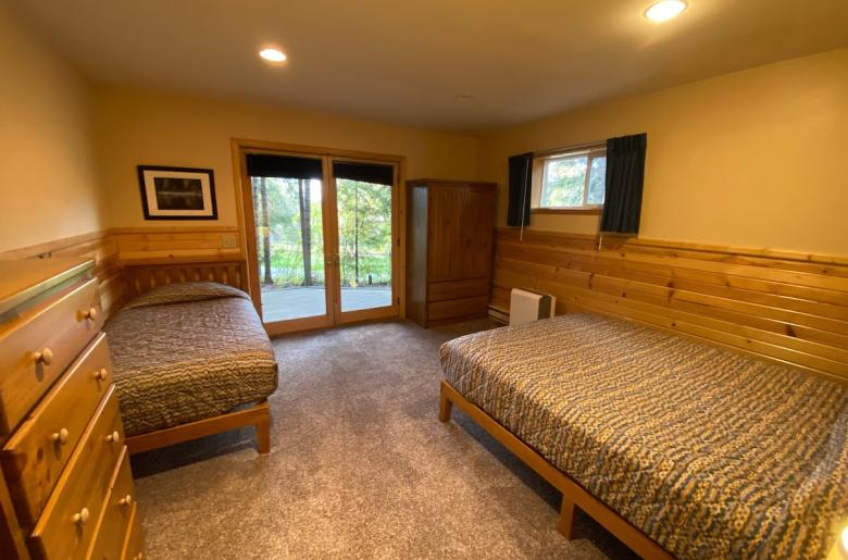 Downstairs bedroom with a queen, twin, and patio doors to the basement patio.