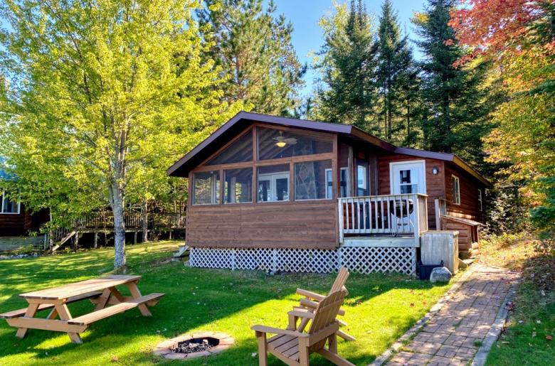 Exterior of Birches showing firepit, picnic table, and screen porch.