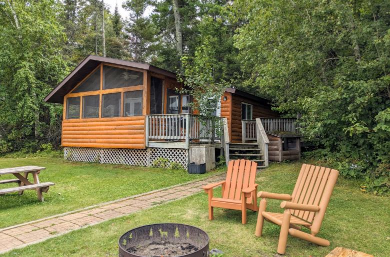 Lincoln cabin showing firepit, picnic table, and screened porch.