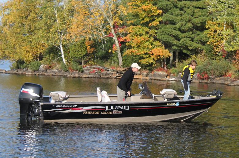 Man and boy fishing from black Lund boat