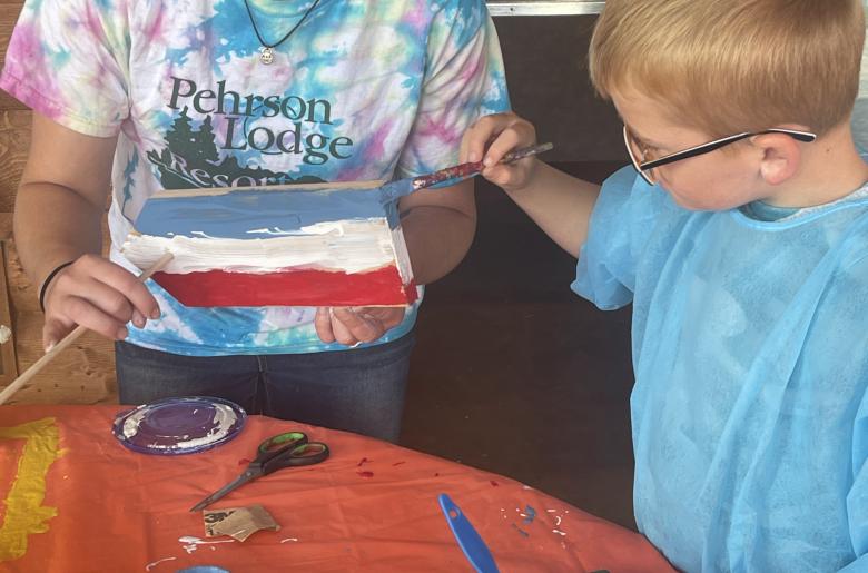 Staff assist children with their model sailboats.