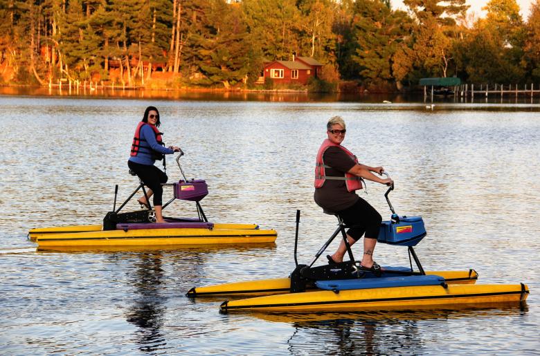 Two women hydro-biking at sunset