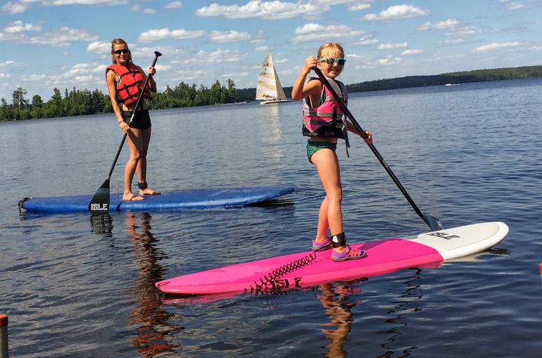 A mother and daughter enjoy the stand up paddle boards
