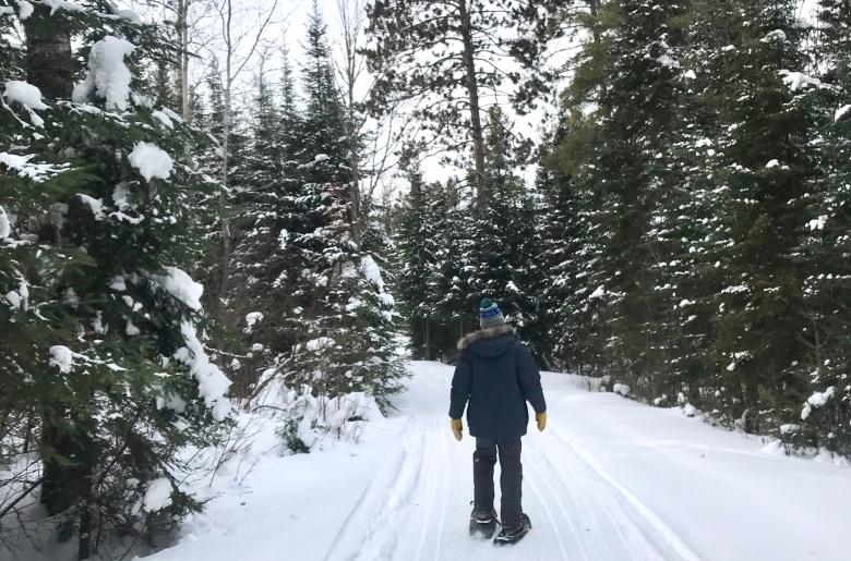 Man snowshoes on Pehrson Lodge on-site hiking trails