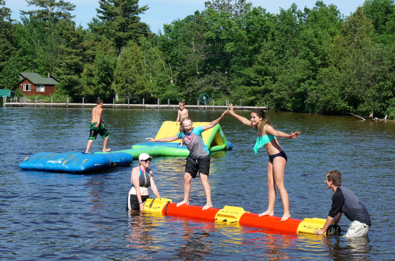 Guests play on the shallow water toys at the beach