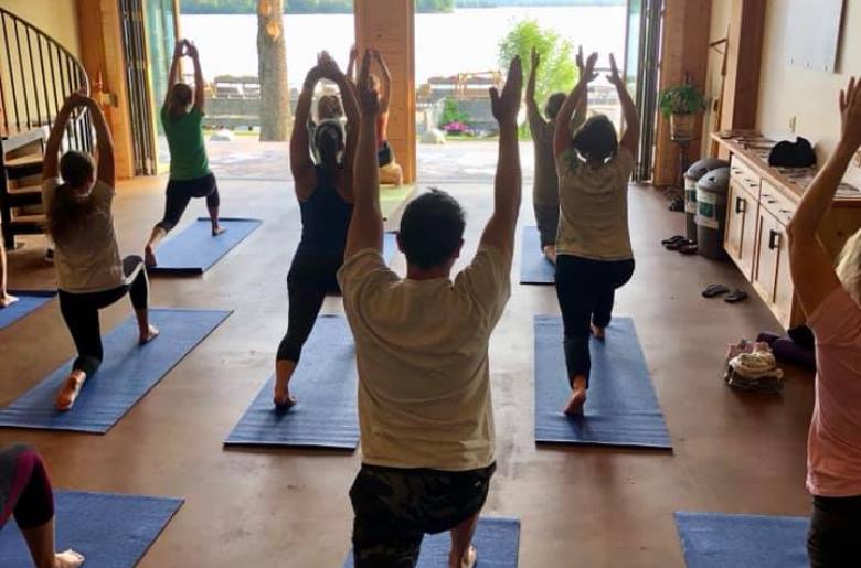 Group yoga in the main lodge with a beautiful lake view.