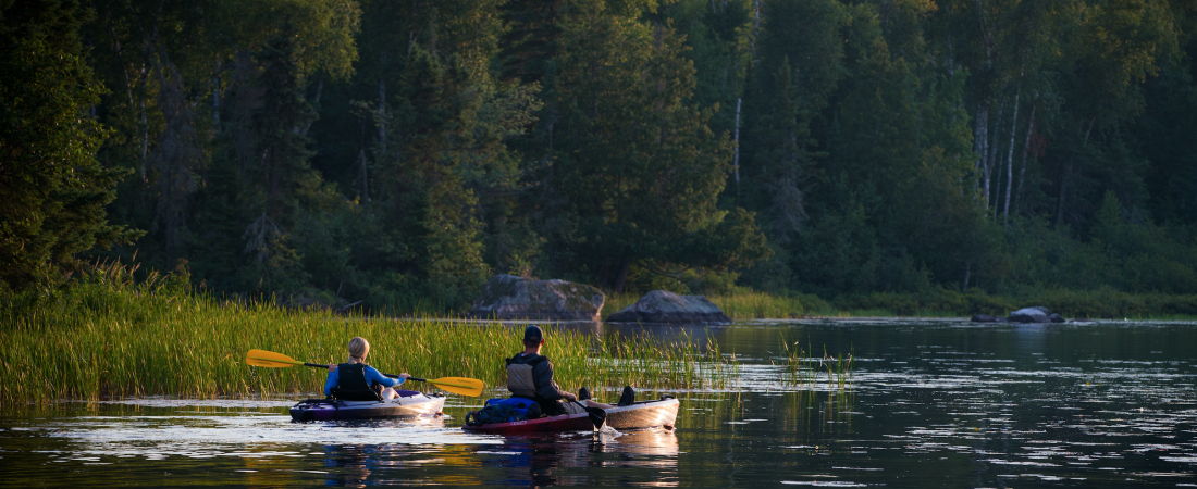 Man and woman kayaking on Lake Vermilion at sunset