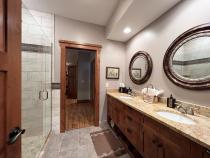 Downstairs bathroom with double sink, shower, and granite.