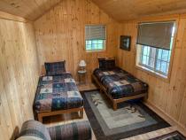 Bunk house with two twin beds, couch, and no plumbing.